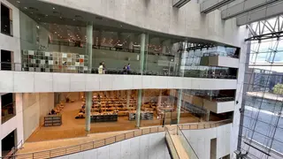 The Royal Danish Library's Black Diamond atrium features glass-walled reading areas, concrete balconies, and a view of the waterfront.