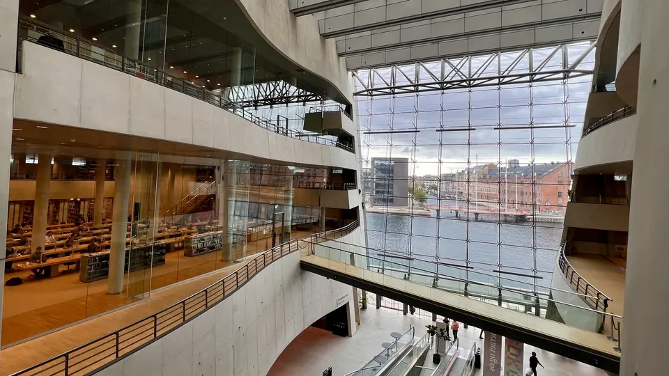 The sweeping atrium of the Black Diamond at the Royal Danish Library overlooks the waterfront through a vast glass wall.