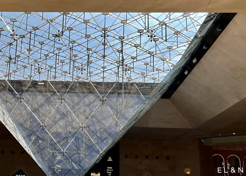 The Inverted Pyramid of the Louvre rises beneath a geometric glass ceiling inside the Carrousel du Louvre.